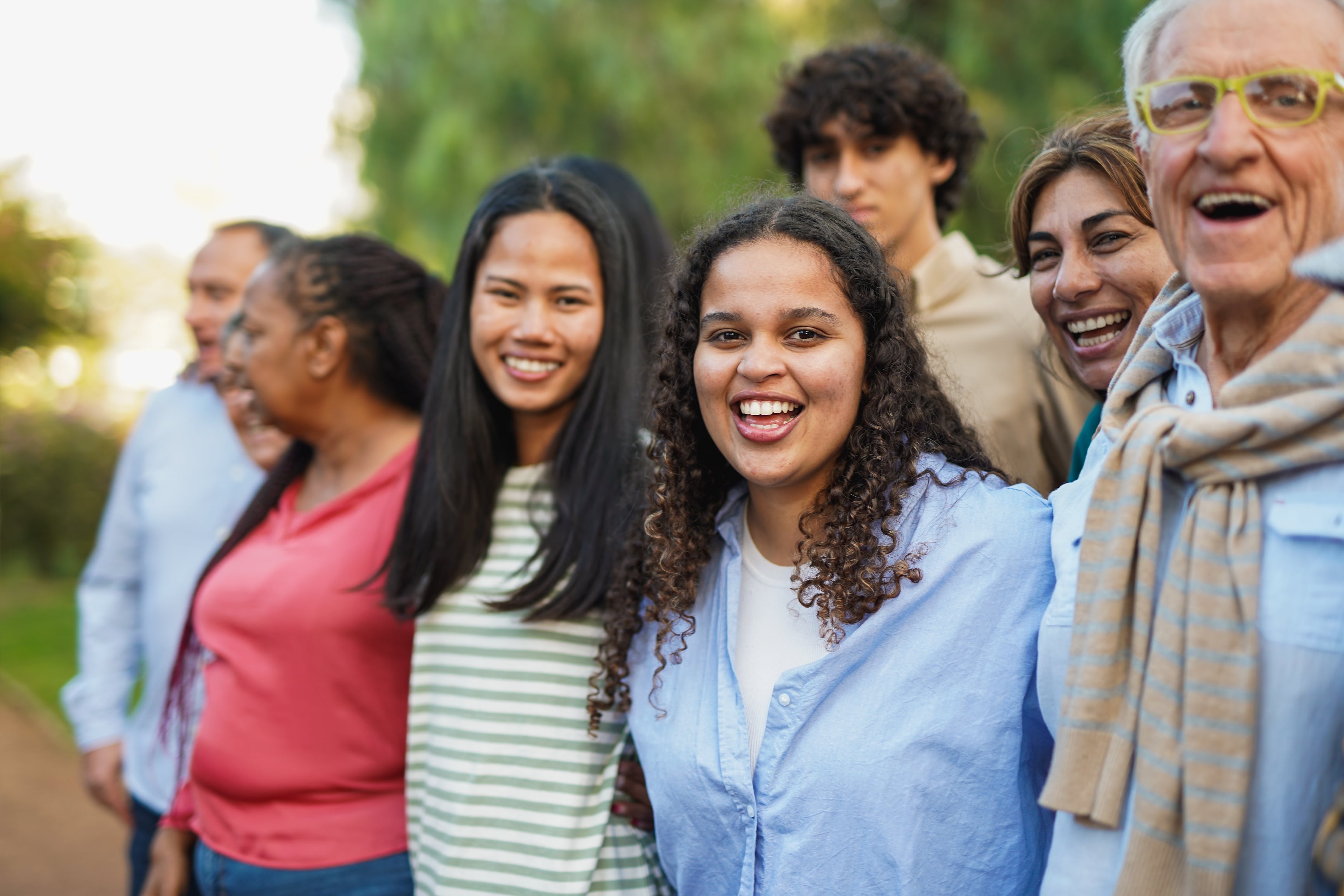 Crowd of people smiling looking at the camera in a park