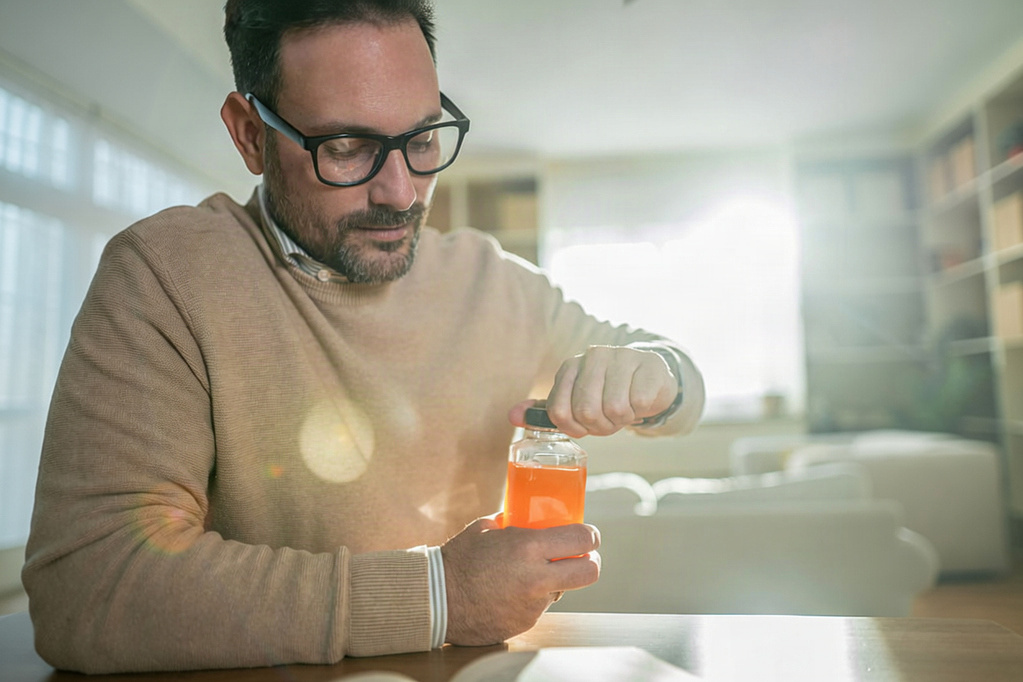 person trying to open a jar of glucose