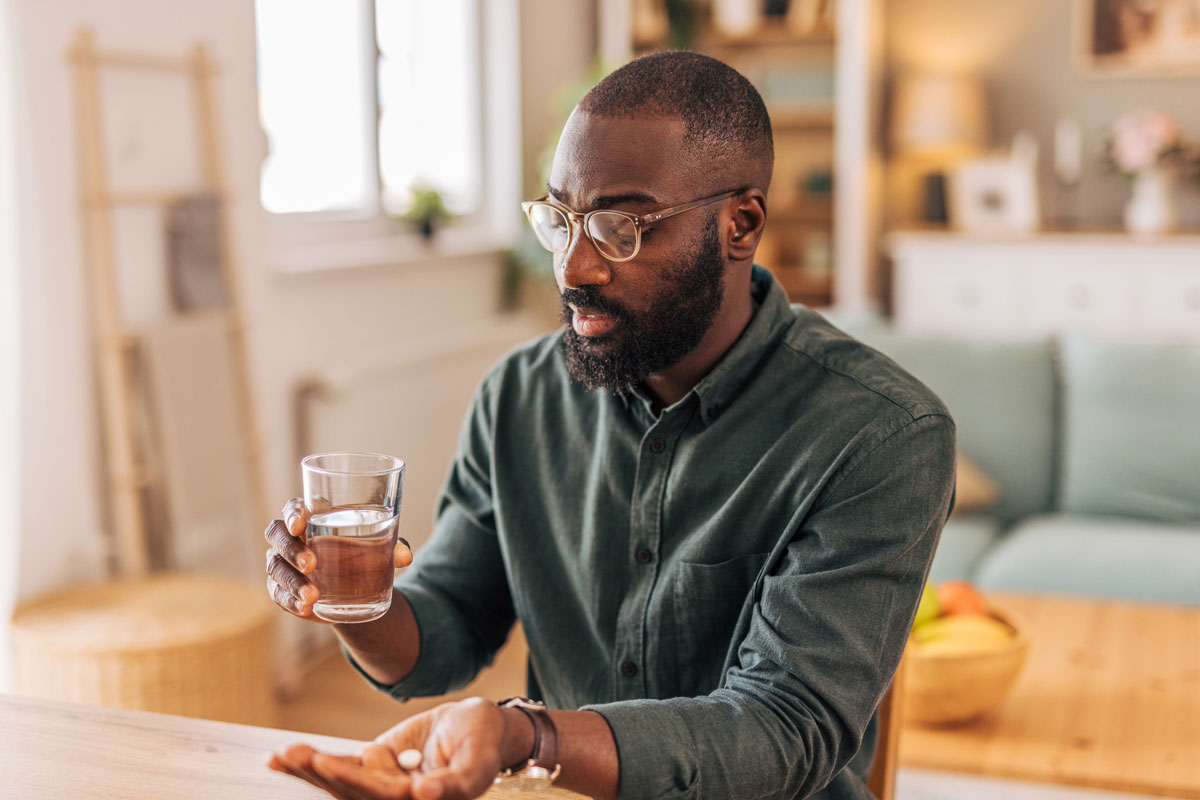 man taking a pill with water