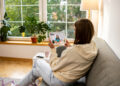 Image depicting a woman on the couch using her tablet for a virtual healthcare visit